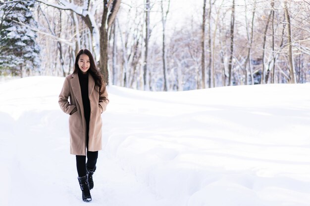 Glückliche junge Reise des Porträt-jungen schönen asiatischen Frauenlächelns und genießen mit Schneewintersaison