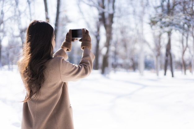 Glückliche junge reise des porträt-jungen schönen asiatischen frauenlächelns und genießen mit schneewintersaison