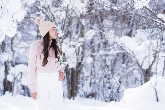 Glückliche junge Reise des Porträt-jungen schönen asiatischen Frauenlächelns und genießen mit Schneewintersaison