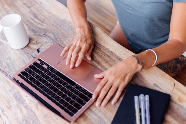 Glückliche kaukasische Frau macht Fernarbeit auf Laptop zu Hause bequemer Ort, der Tee trinkt