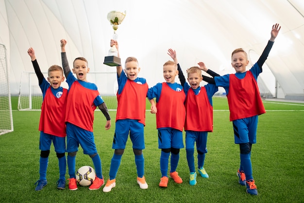 Kostenloses Foto glückliche kinder des vollen schusses mit trophäe