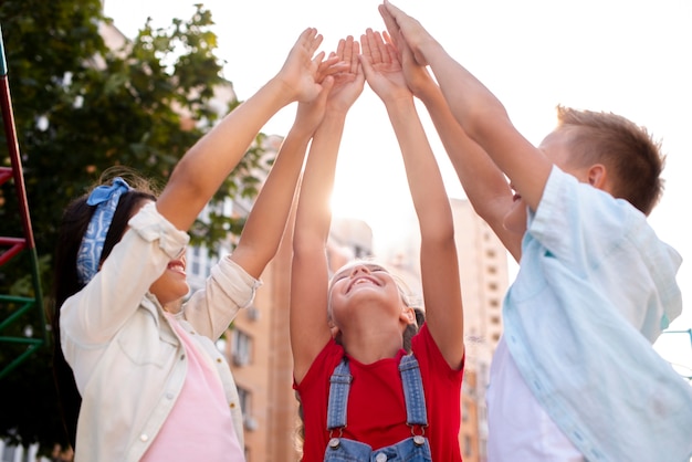 Glückliche Kinder, die ihre Hände anheben