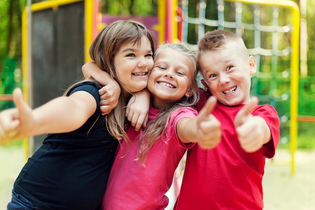 Glückliche Kinder, die ok Zeichen auf Spielplatz zeigen