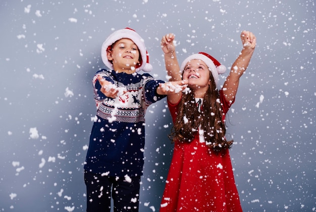 Glückliche Kinder, die Schneeflocke fangen