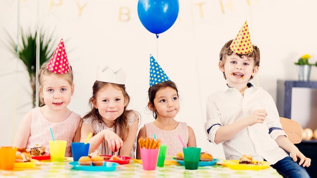 Glückliche Kinder in farbigen Kappen