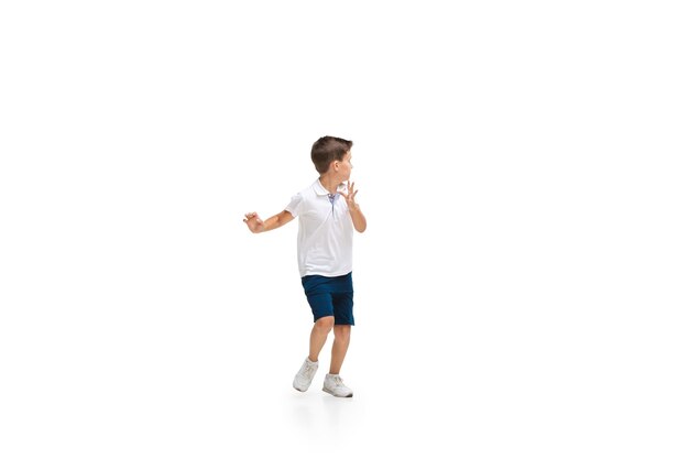 Glückliche Kinder, kleiner und emotionaler kaukasischer Junge, der isoliert auf weiß springt und läuft