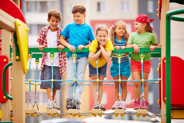 Glückliche Kinder spielen und lachen auf Spielplatz