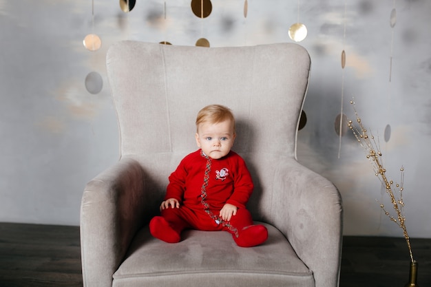 Glückliche lächelnde Familie am Studio auf Hintergrund des Weihnachtsbaums mit Geschenk