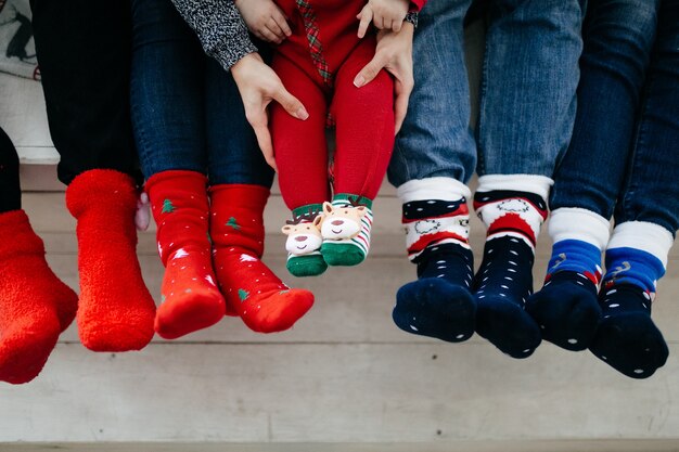 Glückliche lächelnde Familie am Studio auf Hintergrund des Weihnachtsbaums mit Geschenk