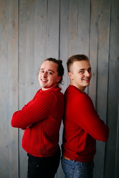 Glückliche lächelnde Familie am Studio auf Hintergrund des Weihnachtsbaums mit Geschenk