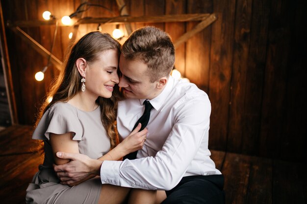 Glückliche lächelnde Familie am Studio auf Hintergrund des Weihnachtsbaums mit Geschenk