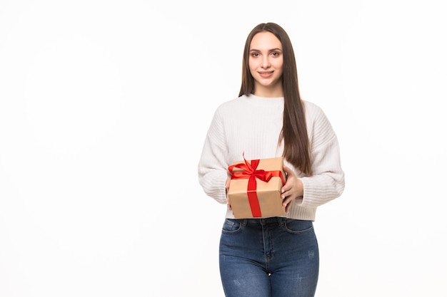 Glückliche lächelnde Frau, die kleine rote Geschenkbox lokalisiert auf weißer Wand hält