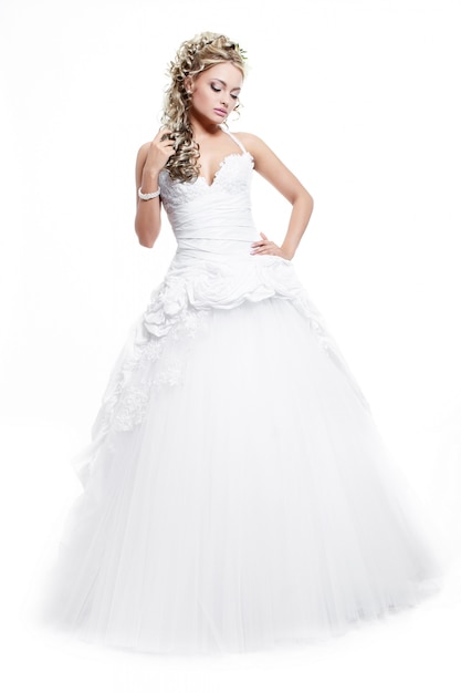 Glückliche lächelnde schöne Braut im weißen Hochzeitskleid mit Frisur und hellem Make-up