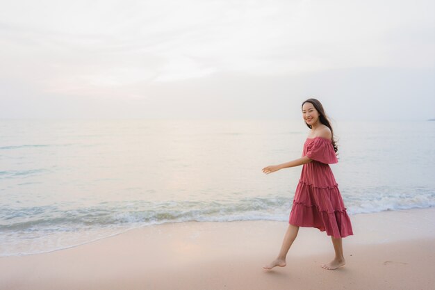 Glückliche Lächelnfreizeit der schönen jungen asiatischen Frau des Porträts auf dem Strandmeer und -ozean