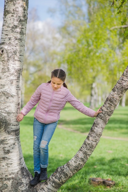 Glückliche Mädchen spielen auf einem Baum