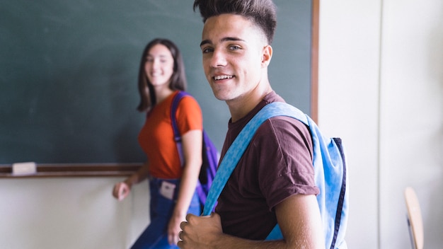 Glückliche Mitschüler mit Rucksäcken