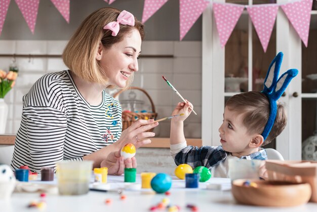 Glückliche Mutter, die mit niedlichem kleinen Jungen spielt