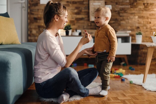 Glückliche Mutter genießt es, Zeit mit ihrem kleinen Sohn zu Hause zu verbringen