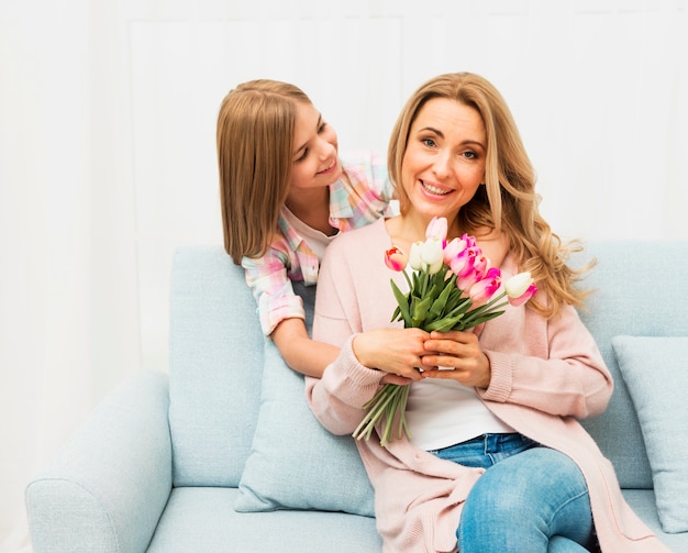 Glückliche Mutter mit Blumen von der Tochter