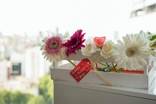 Glückliche Mutter-Tagesaufschrift mit Blumen im Kasten
