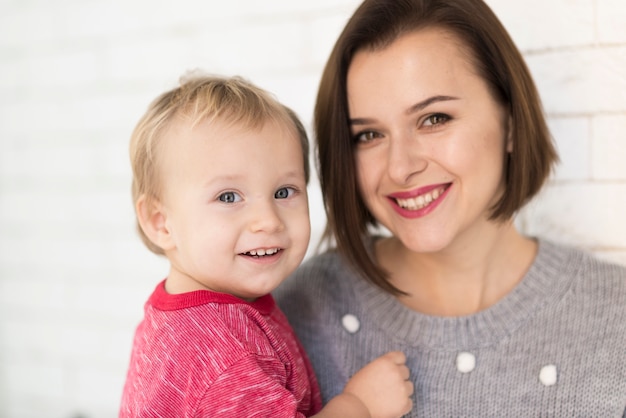 Glückliche Mutter und Baby bei Röschen lächelnd