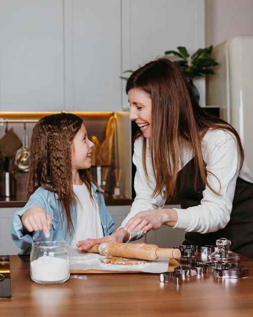 Glückliche Mutter und Tochter, die in der Küche zu Hause kochen