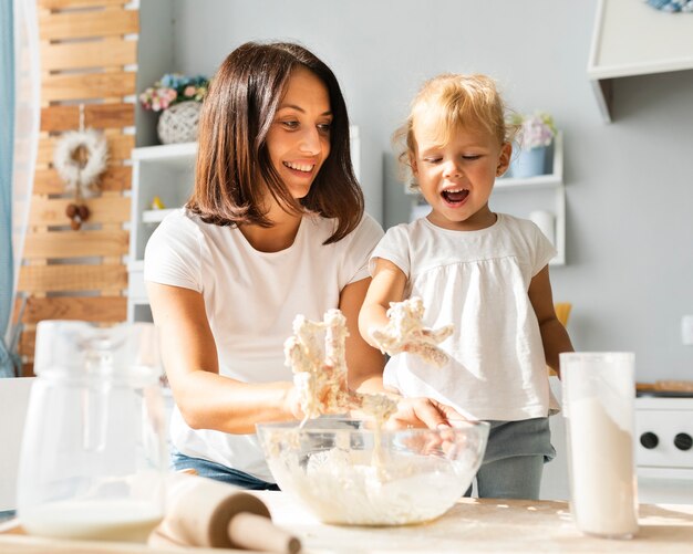 Glückliche Mutter und Tochter, die Teig zubereitet