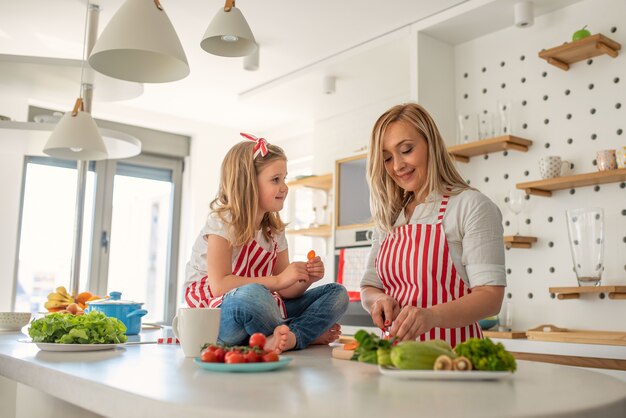 Glückliche Mutter und Tochter, die zusammen kochen