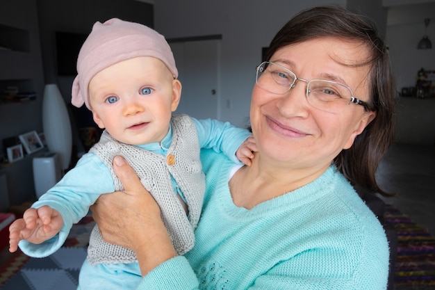 Glückliche neue Großmutter, die mit niedlicher kleiner Enkelin aufwirft