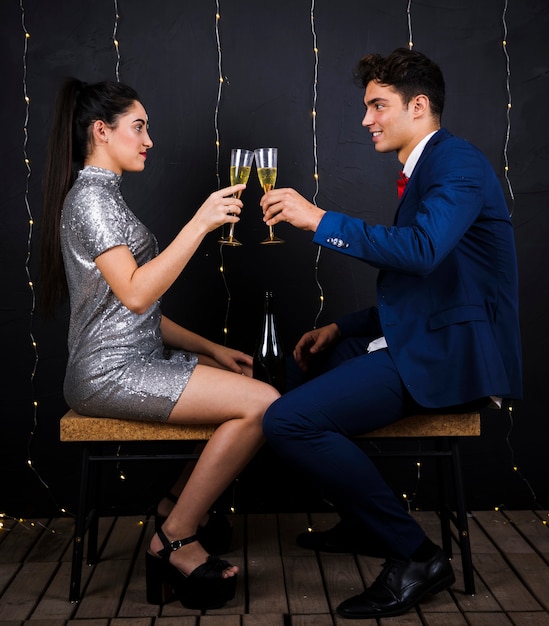 Glückliche Paare, die Gläser Champagner klopfen