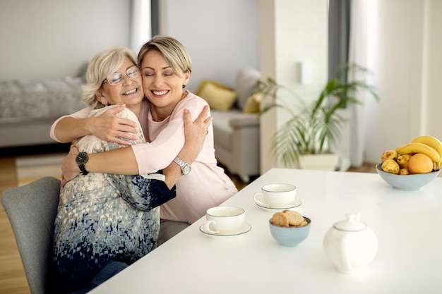 Kostenloses Foto glückliche reife mutter und ihre erwachsene tochter, die sich zu hause umarmen