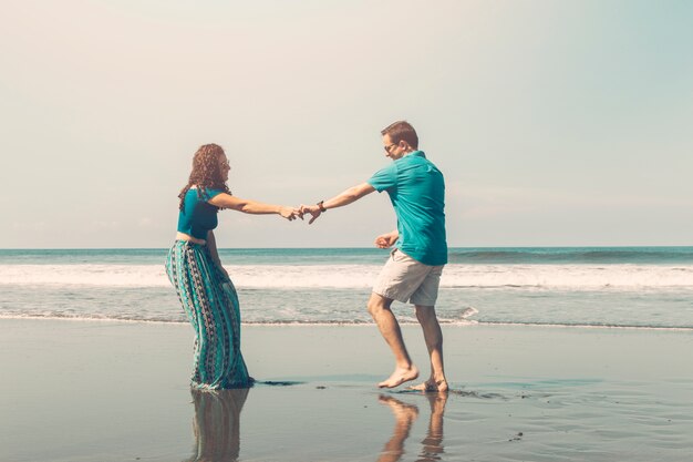 Glückliche romantische Paare, die Spaß am Strand haben