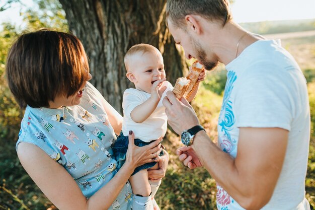 Glückliche schöne Familie auf dem großen Garten auf der Dämmerungszeit