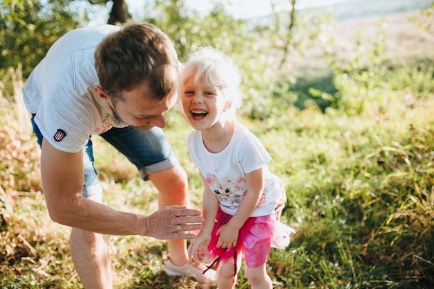 Glückliche schöne Familie auf dem großen Garten auf der Dämmerungszeit