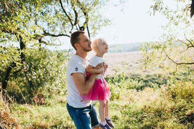 Glückliche schöne Familie auf dem großen Garten auf der Dämmerungszeit