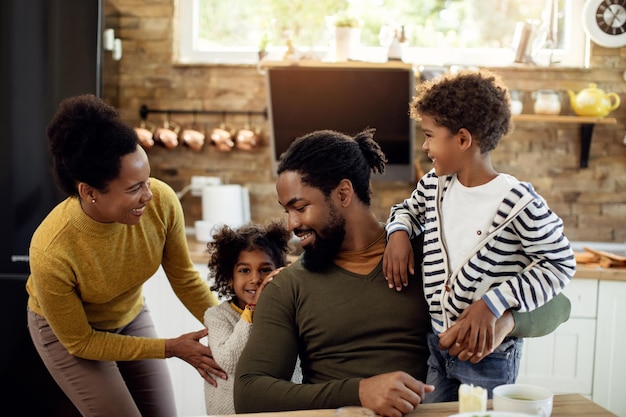 Glückliche schwarze Eltern, die sich zu Hause mit ihrem Sohn und ihrer Tochter amüsieren