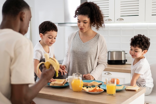 Glückliche schwarze Familie, die beim Lächeln frühstückt