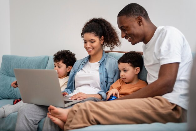 Glückliche schwarze Familie, die einen Film auf Laptop sieht