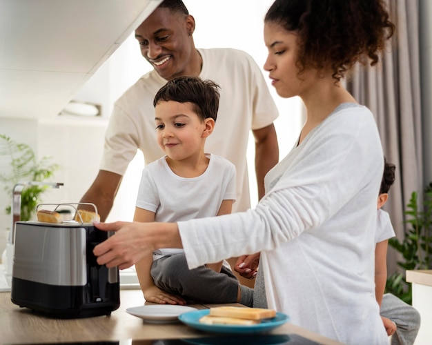 Glückliche schwarze Familie, die Frühstücksnahrung zubereitet