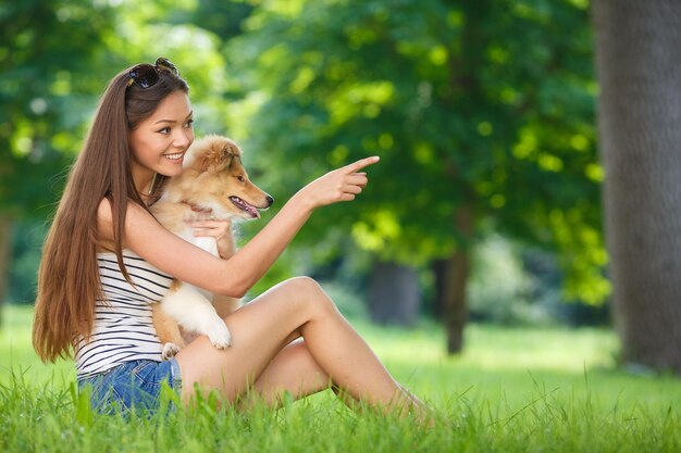 glückliche süße Frau mit Hund im Freien