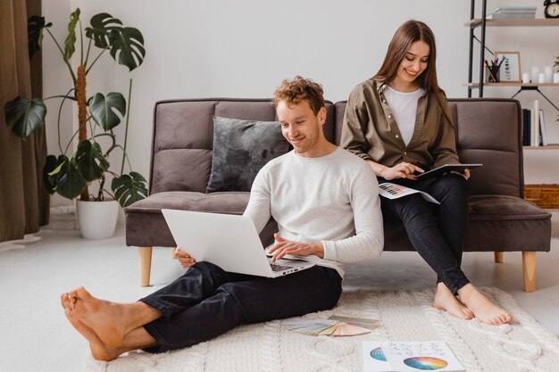 Glückliche und liebevolle Frau und Mann, die Pläne machen, das Haus zusammen zu renovieren