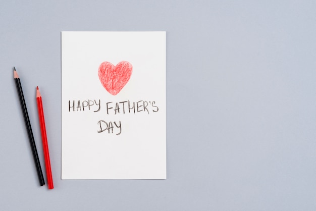 Glückliche Vatertagsaufschrift auf Papier mit Bleistiften