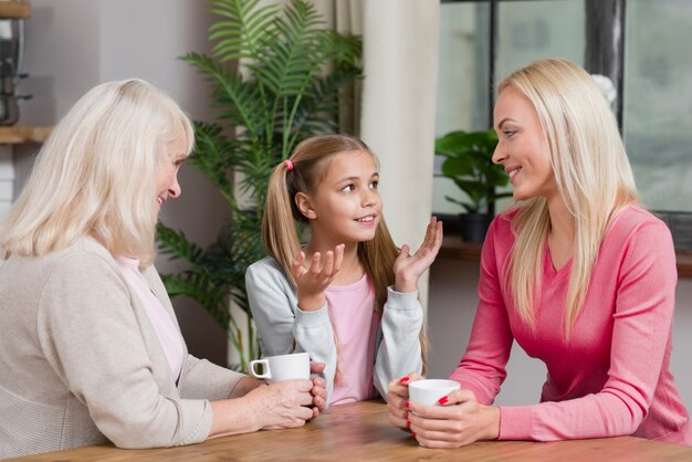 Glückliche weibliche Generation sprechen miteinander in der Küche
