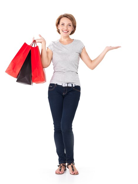 Glückliche weiße Frau mit Einkaufstüten auf Weiß