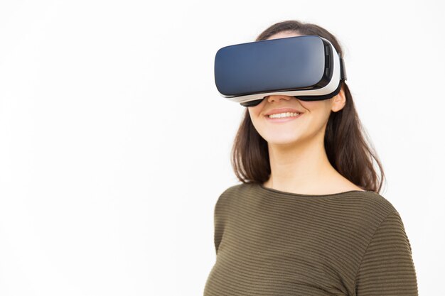 Glückliche zufriedene Frau in VR-Kopfhörer lächelnd an der Kamera