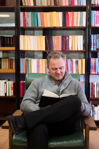 Glücklicher älterer Mann, der ein Buch liest