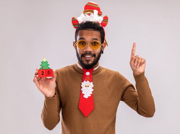 Glücklicher Afroamerikanermann in braunem Pullover und Weihnachtsmannrand