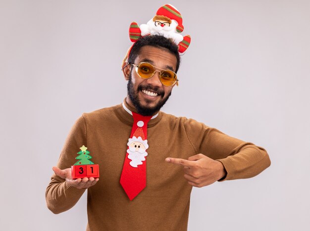 Glücklicher Afroamerikanermann in braunem Pullover und Weihnachtsmannrand