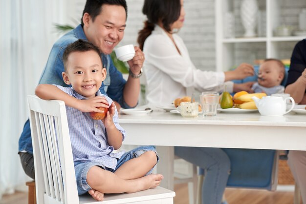 Glücklicher asiatischer Junge am Frühstück mit Familie