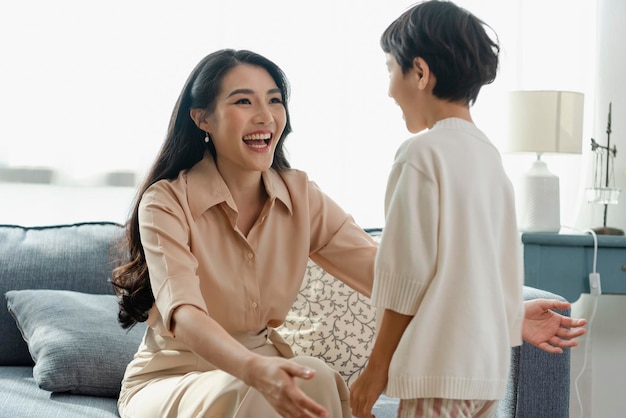 Kostenloses Foto glücklicher asiatischer zarter sohn, der mutter am muttertag während der feiertagsfeier zu hause umarmt